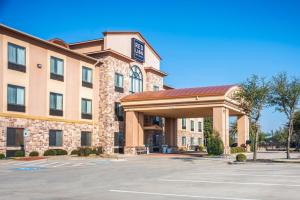 um hotel com um parque de estacionamento em frente em Red Lion Inn & Suites Mineral Wells em Mineral Wells