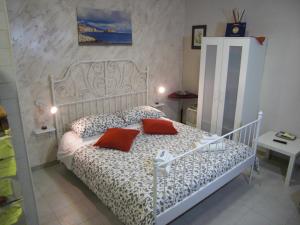 ナポリにあるIl Rifugio di Pulcinella restylingのベッドルーム1室(白いベッド1台、赤い枕2つ付)