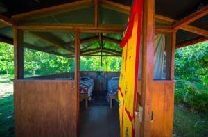 un porche de una casa con una cama en ella en Kirpal Meditation and Ecological Center en Pahoa
