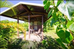 a pavilion with a table and chairs in a garden at Kirpal Meditation and Ecological Center in Pahoa