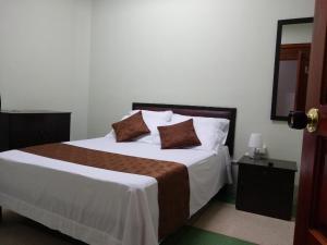a bedroom with a large bed with two pillows on it at Hotel Cafetto in Pereira