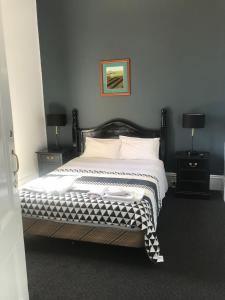 
a bedroom with a bed and a dresser at The Federal Boutique Hotel in Fremantle

