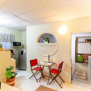 a dining room with a table and red chairs at Casita mi nuevo amanecer in Santa Marta