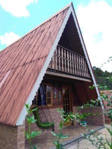 a small house with a brown roof with a porch at Recanto Mauá - Chalé Azaleia in Visconde De Maua
