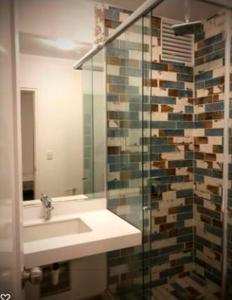 uma casa de banho com um lavatório e uma cabina de duche em vidro. em Casa Paracas em Paracas