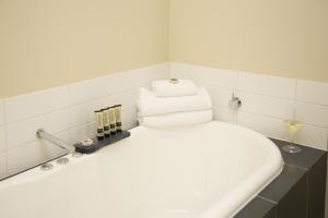 a white bath tub sitting next to a white sink at The Sebel Launceston in Launceston
