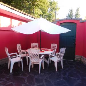 einen weißen Tisch und Stühle mit einem weißen Regenschirm in der Unterkunft Casa barrio Los Troncos "La Magnolia" in Mar del Plata
