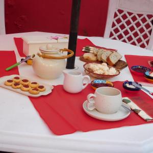 a table with cups and plates of food and pastries at Casa barrio Los Troncos "La Magnolia" in Mar del Plata +33 photos