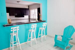 a kitchen with a blue counter and stools at QuillaHost Tropical Apartment in Barranquilla