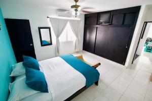 a bedroom with a large bed with blue pillows at QuillaHost Tropical Apartment in Barranquilla