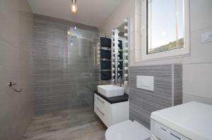 RakaljにあるApartments Milanのトイレ、洗面台、鏡のあるバスルーム +47枚の写真