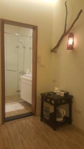 a bathroom with a shower and a table and a sink at Chien Ching B&B in Jiufen