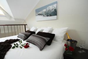 a bed with black and white pillows and flowers on it at Summit Ridge Alpine Lodge in Falls Creek