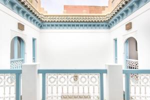 a white building with a blue fence at Riad Ayla avec Piscine Privée in Marrakesh