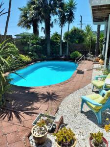 a swimming pool with a chair and some plants at The Harbour View Tairua in Tairua