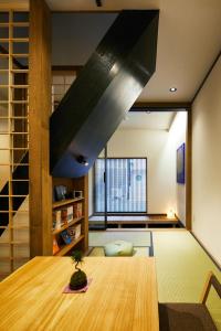 un soggiorno con tavolo in legno e una grande finestra di Machizukitei a Kyoto