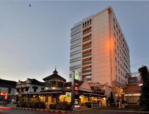 ein hohes Gebäude mitten in einer Stadt in der Unterkunft Gino Feruci Kebon Jati by KAGUM Hotels in Bandung