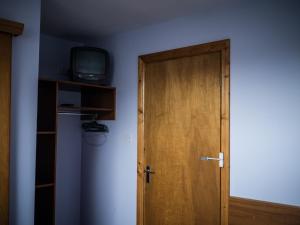 a room with a door and a tv on a wall at The Dingle Pub Rooms in Dingle