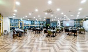 a restaurant with tables and chairs in a building at Hotel Shalom Jeju in Jeju