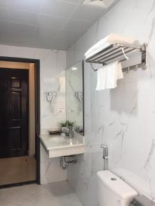 a bathroom with a toilet and a sink and a mirror at New Sun Hotel in Ha Long +14 photos