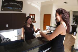 Due donne in piedi al bancone di un salone di Bella Vista Park Hotel a Ilha Solteira