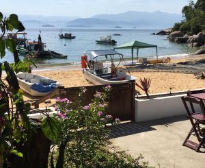 a boat on the beach with boats in the water at Casarao da Praia in Praia Vermelha