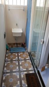 a bathroom with a shower and a sink and a tiled floor at Casa em Arraial do Cabo in Arraial do Cabo +13 photos