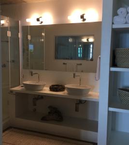 a bathroom with two sinks and a mirror at Casarao da Praia in Praia Vermelha