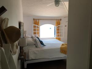 1 dormitorio con 1 cama y ventana abierta en Casarao da Praia, en Praia Vermelha