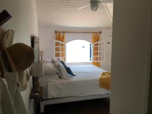 a bedroom with a bed with an open window at Casarao da Praia in Praia Vermelha