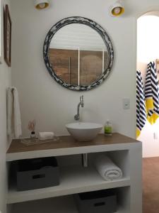 a bathroom with a sink and a mirror on the wall at Casarao da Praia in Praia Vermelha
