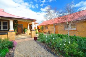 Casa amarilla con techo rojo y jardín en Stephanette's Cottage en Lights Pass