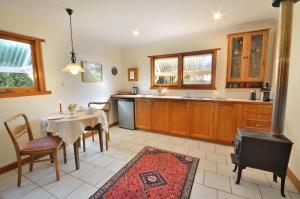 una cucina e una sala da pranzo con tavolo e sedie di Stephanette's Cottage a Lights Pass