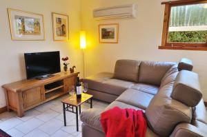 a living room with a couch and a flat screen tv at Stephanette's Cottage in Lights Pass