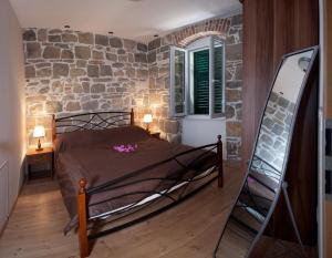 1 dormitorio con cama y pared de piedra en Casa Matošića Apartments, en Split