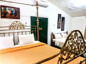 1 dormitorio con 2 camas y 1 silla en nDalem Gamelan, en Yogyakarta