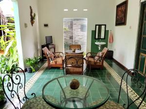- un salon avec une table et des chaises en verre dans l'établissement nDalem Gamelan, à Yogyakarta