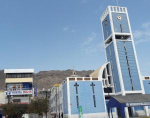 a tall blue building with a clock tower at HOSTAL HOGAR 3 Estrellas - CHEPÉN in Chepén