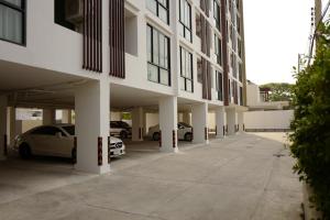 um edifício com carros estacionados num parque de estacionamento em 185 Residence em Khon Kaen