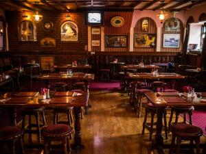 un restaurant vide avec des tables et des chaises en bois dans l'établissement The Dingle Pub Rooms, à Dingle