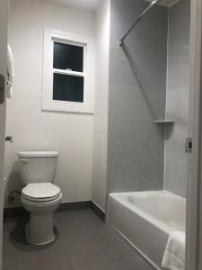 a white toilet sitting next to a bath tub at Mission Inn in San Francisco