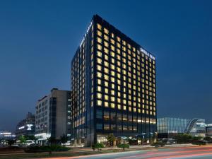 a tall building with many windows in a city at Shilla Stay Cheonan in Cheonan