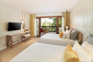 a hotel room with two beds and a television at Bandara Spa Resort & Pool Villas, Samui in Bophut