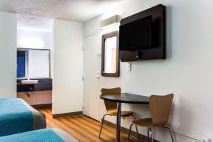 um quarto com uma mesa e uma televisão na parede em Motel-6 Lagrange Ga em La Grange