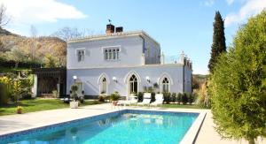 a villa with a swimming pool in front of a house at Relais La Placa in Francavilla di Sicilia
