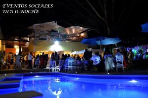 a group of people standing around a pool at night at Hotel Finca Los Cocos in Cuernavaca