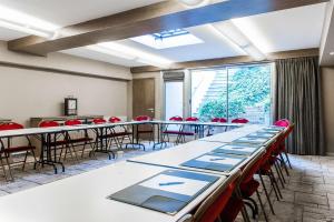 a room with tables and chairs and a large window at Best Western Saint-Louis - Grand Paris - Vincennes in Vincennes