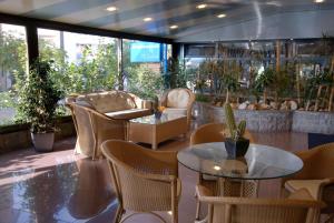 カステルデフェルスにあるベストウエスタン ホテル メディテラネオの椅子とテーブルと植物のあるレストラン