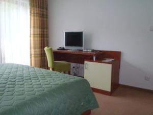 a bedroom with a bed and a desk with a computer at Hotel Bazant in Karlovy Vary