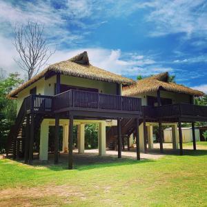 a large house with a thatched roof at Muri Shores in Rarotonga